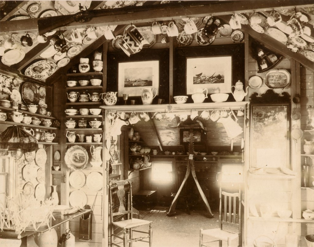 The cottage of Mrs. Evelyn Underhill, circa 1900. The walls and ceiling of the cottage interior were lined with china collections, dishes, and tea services.